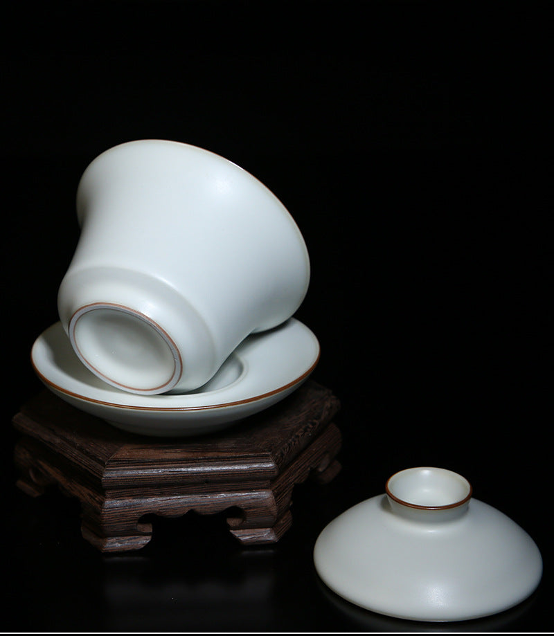 The picture of the tea bowl with moon-white glaze of Ru Kiln. The tea bowl has a simple and elegant shape, with an open mouth, a curved belly and a small circular foot. The lines are smooth and natural. The moon-white glaze evenly covers the inner and outer walls of the bowl. The glaze surface is smooth and delicate, like fat or jade, giving people a warm, smooth and mellow texture. 