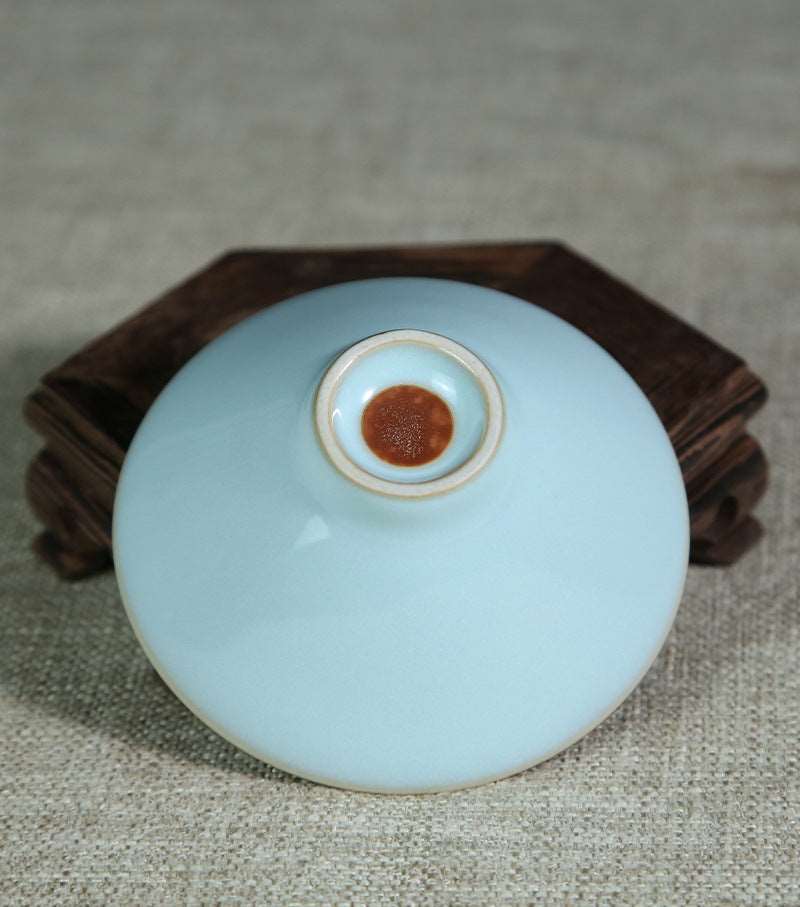 This picture shows a Ru porcelain tea cup with sky-blue glaze. The cup has a rounded and plump shape, and its rim is smooth. Against the backdrop of the sky-blue glaze, it looks like a fine work of art, giving off an air of tranquility and elegance. 