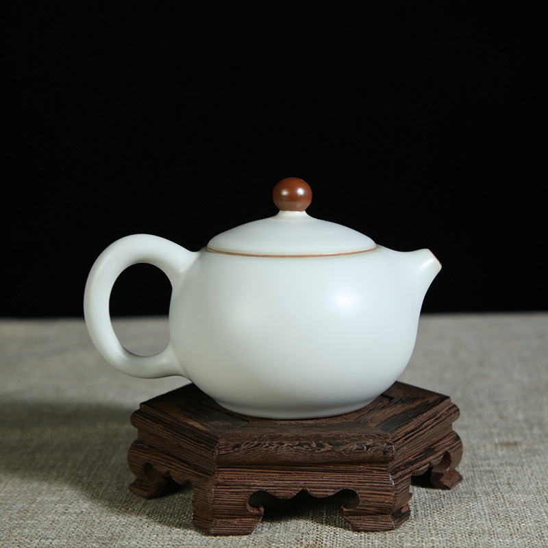 The picture of the teapot with moon-white glaze of Ru Kiln. The body of the teapot has smooth and elegant lines, being round and full, showing a simple, unsophisticated and magnificent modeling style. Its moon-white glaze is like the first snow in winter, with a slight bluish-gray tint in the whiteness, emitting a soft luster under the light, giving people a sense of coolness and elegance. The spout and the handle of the teapot are exquisitely designed with a harmonious proportion, perfectly integrating wit