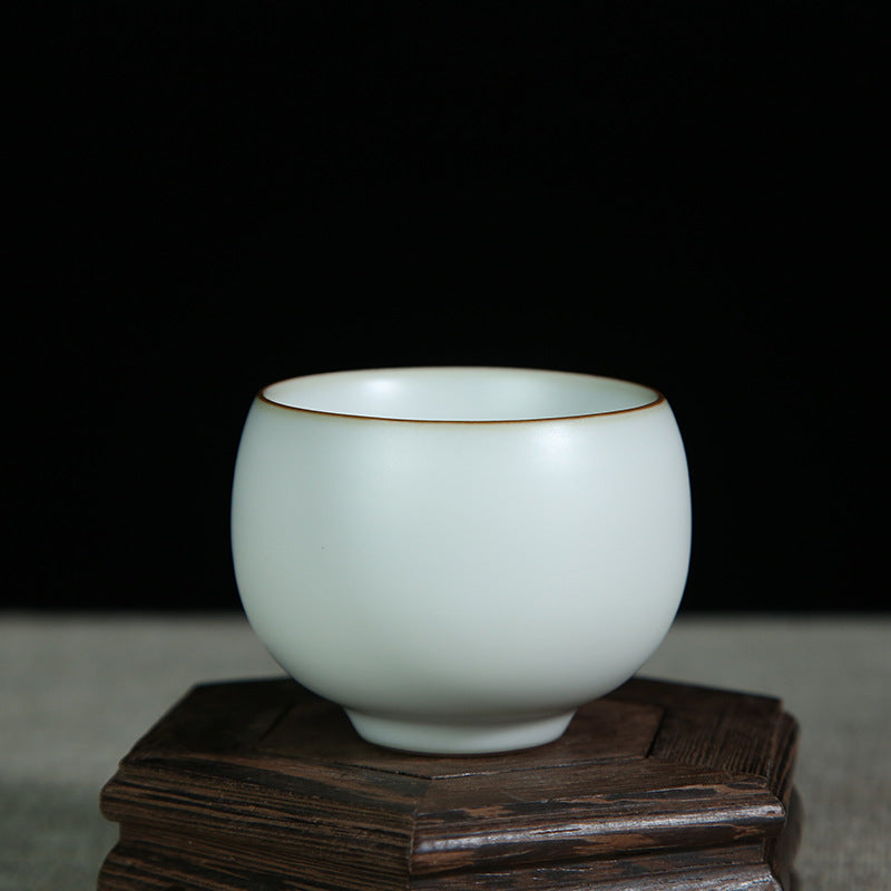 The picture of the tea bowl with moon-white glaze of Ru Kiln. The tea bowl has a simple and elegant shape, with an open mouth, a curved belly and a small circular foot. The lines are smooth and natural. The moon-white glaze evenly covers the inner and outer walls of the bowl. The glaze surface is smooth and delicate, like fat or jade, giving people a warm, smooth and mellow texture. 