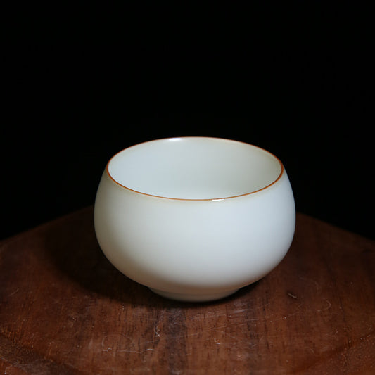 The picture of the tea bowl with moon-white glaze of Ru Kiln. The tea bowl has a simple and elegant shape, with an open mouth, a curved belly and a small circular foot. The lines are smooth and natural. The moon-white glaze evenly covers the inner and outer walls of the bowl. The glaze surface is smooth and delicate, like fat or jade, giving people a warm, smooth and mellow texture. 