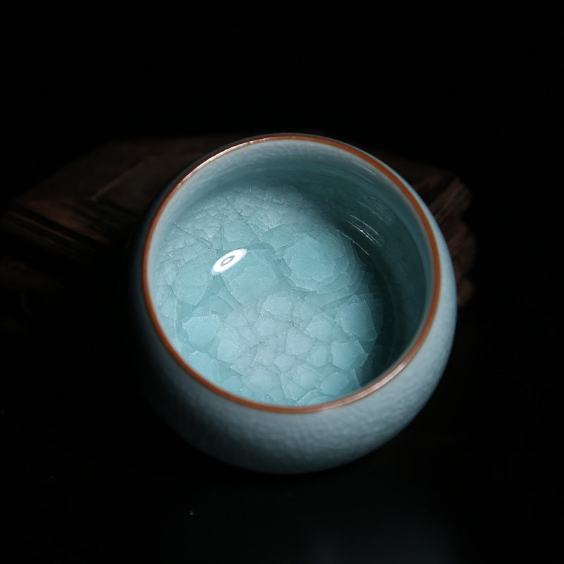 This picture shows a Ru porcelain tea cup with sky-blue glaze. The cup has a rounded and plump shape, and its rim is smooth. Against the backdrop of the sky-blue glaze, it looks like a fine work of art, giving off an air of tranquility and elegance. 