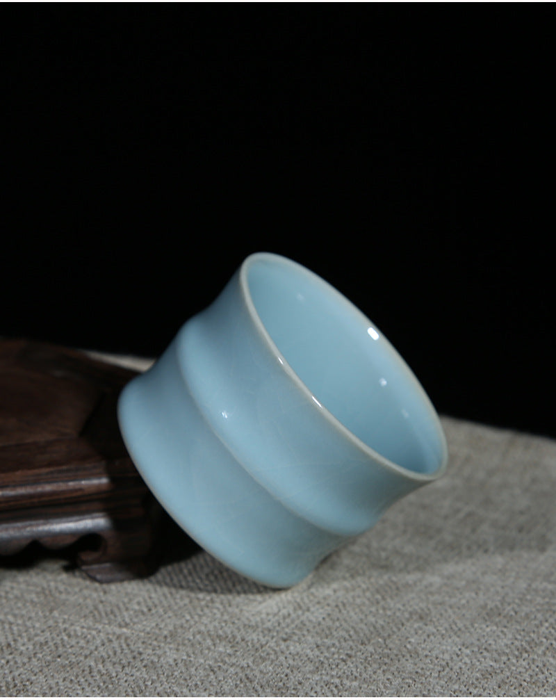 A Ru porcelain tea cup with sky-blue glaze. The body of the cup is in an elegant bamboo shape with smooth lines. The whole cup is covered by the light and elegant sky-blue glaze, fully showing a primitive and classic charm. 