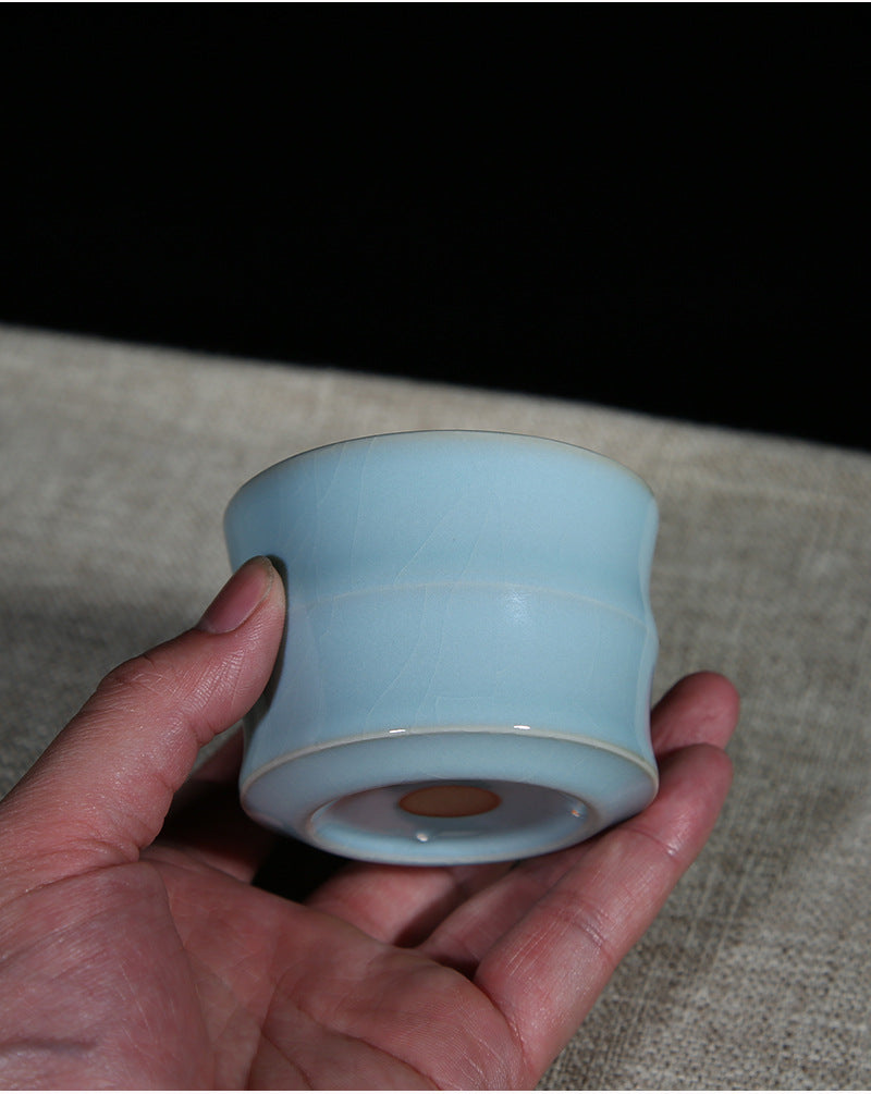 A Ru porcelain tea cup with sky-blue glaze. The body of the cup is in an elegant bamboo shape with smooth lines. The whole cup is covered by the light and elegant sky-blue glaze, fully showing a primitive and classic charm. 