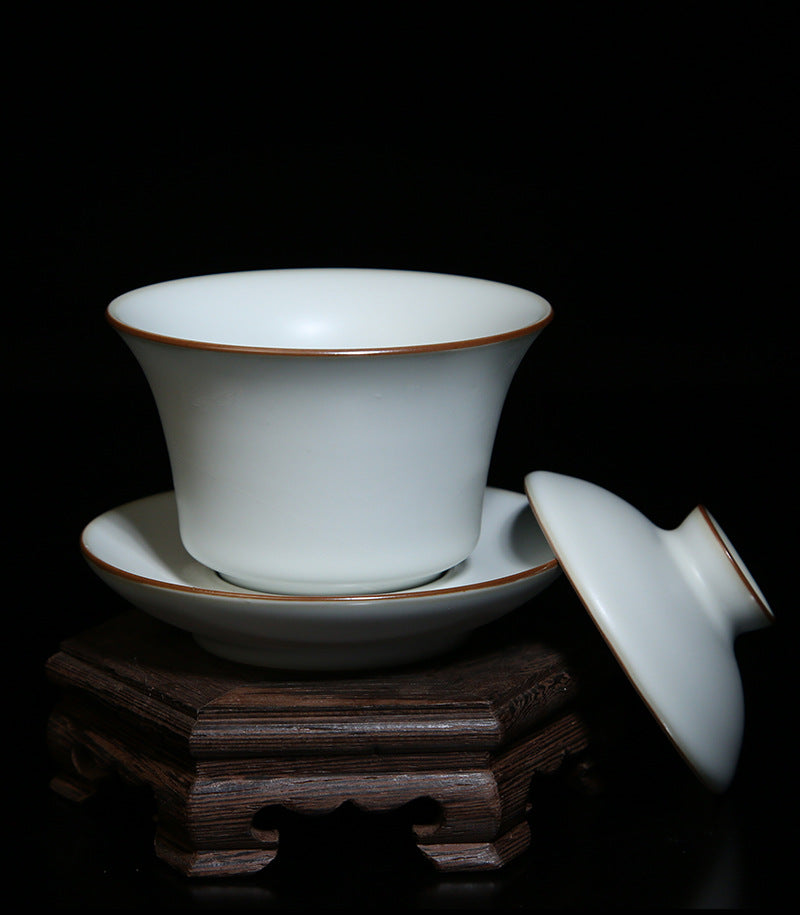 The picture of the tea bowl with moon-white glaze of Ru Kiln. The tea bowl has a simple and elegant shape, with an open mouth, a curved belly and a small circular foot. The lines are smooth and natural. The moon-white glaze evenly covers the inner and outer walls of the bowl. The glaze surface is smooth and delicate, like fat or jade, giving people a warm, smooth and mellow texture. 