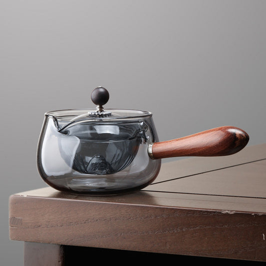 The smoky gray glass teapot has a unique color, presenting a low-key and luxurious style. Its rounded body has smooth lines, and the glass is crystal clear. The lid fits tightly with the body, showing the charm of the delicate tea art. 