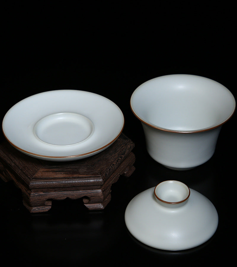 The picture of the tea bowl with moon-white glaze of Ru Kiln. The tea bowl has a simple and elegant shape, with an open mouth, a curved belly and a small circular foot. The lines are smooth and natural. The moon-white glaze evenly covers the inner and outer walls of the bowl. The glaze surface is smooth and delicate, like fat or jade, giving people a warm, smooth and mellow texture. 