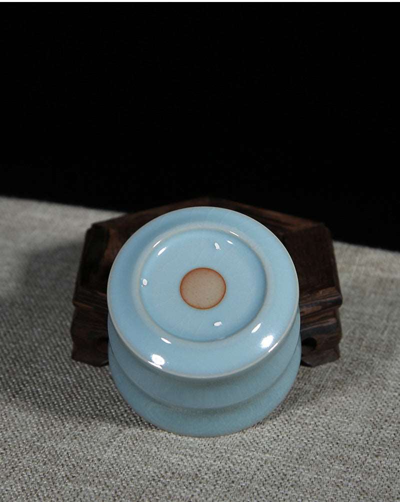 A Ru porcelain tea cup with sky-blue glaze. The body of the cup is in an elegant bamboo shape with smooth lines. The whole cup is covered by the light and elegant sky-blue glaze, fully showing a primitive and classic charm. 